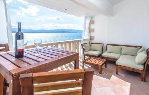 穆尔维察Villa Majda at the Paradise beach的阳台上的木桌上放一瓶葡萄酒