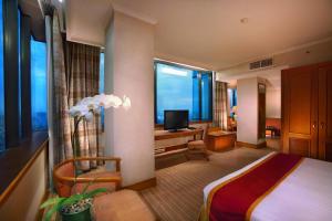 雅加达梅纳拉半岛酒店的酒店客房设有一张床、一张书桌和窗户。