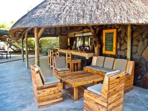 KamanjabPalmwag Camping2Go的餐厅设有酒吧,配有椅子和桌子