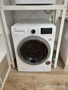雷诺河畔卡萨莱基奥Poema Apartment的架子上设有电视的白色洗衣机