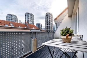 布拉迪斯拉发Business & Family Ambiente Apartments的阳台设有木凳和盆栽植物