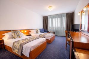 萨格勒布Hotel Novi Zagreb的酒店客房配有两张床和一张书桌