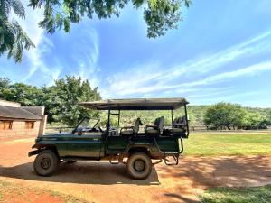 卡利南Zebra Nature Reserve的停在田野前的绿色吉普车