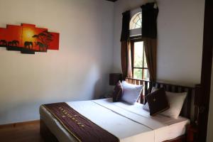 尼甘布帕帆拿酒店的一间卧室设有一张床和一个窗口