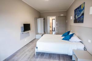 卡坦扎罗Il Gelso Guest House的卧室配有带蓝色枕头的大型白色床