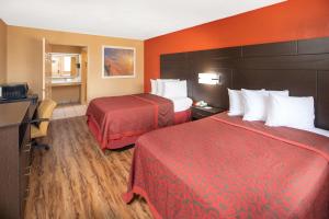 图珀洛图珀洛戴斯酒店的酒店客房带两张床和橙色墙壁