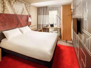伦敦宜必思伦敦坎宁镇酒店的酒店客房设有一张白色大床和一张书桌