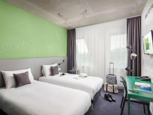韦切什布达佩斯机场宜必思尚品酒店的酒店客房设有两张床和绿色的墙壁。