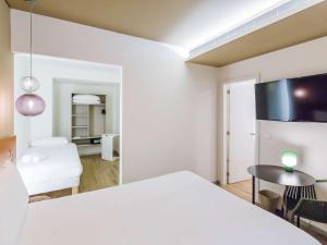 里斯本Ibis Styles Lisboa Centro Marquês de Pombal的客厅配有白色桌子和椅子