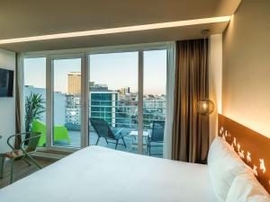 里斯本Ibis Styles Lisboa Centro Marquês de Pombal的酒店客房设有一张床和一个大窗户