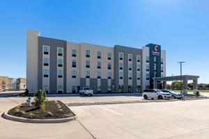 鲍尔奇斯普林斯Comfort Inn & Suites Balch Springs - SE Dallas的停车场内停放汽车的大型建筑