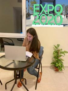 迪拜Expo Backpackers的坐在桌子上的手提电脑的女人