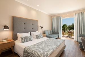 耶奥伊乌波利斯派洛特滨海度假酒店的一间卧室配有一张床、一张沙发和一把椅子
