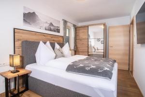 维辛Apart Dahoam的卧室配有一张白色大床和木制床头板