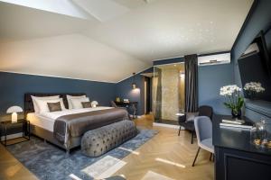 奥帕提亚Heritage Hotel Imperial - Liburnia的卧室拥有蓝色的墙壁,配有一张床和一张沙发