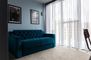 利物浦The Baltic Hotel的客厅设有蓝色沙发,配有窗户