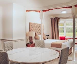 克劳利Trivelles Waterhall Country Gatwick Hotel & airport parking的酒店客房配有一张床铺和一张桌子。