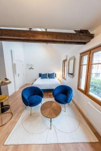 圣康坦Le Magnifique Appart'Hotel Le Gatsby的一间卧室配有2把蓝色椅子和1张床