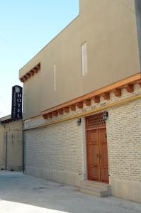 布哈拉Sukhrob Barzu Hotel的建筑的一侧有一扇棕色的门