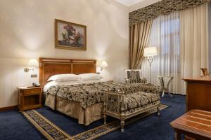基辅Premier Palace Hotel Kyiv的酒店客房设有一张大床和一张桌子。