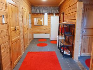 伊纳利伊纳利湖移动小屋露营地的一间带木墙和红色地毯的浴室