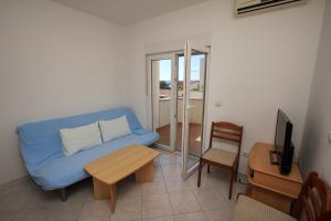 波弗加纳Apartments Dubrovnik Two的客厅配有蓝色的沙发和桌子
