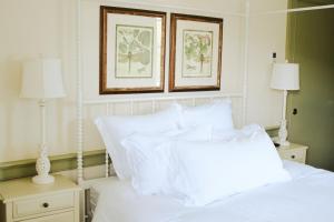 埃利科特城Mary's Land Farm的卧室配有2张白色的床和2张墙上的照片