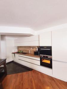 多纳瓦利Apartmán 27, Kamzík的厨房拥有白色的墙壁和木地板
