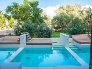 拉加纳斯Castelli Hotel-Adults Only的一座游泳池,旁边设有两张床