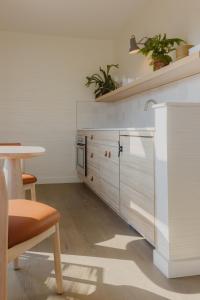 绍斯霍尔德The Shoals Suites & Slips的厨房配有白色橱柜和桌子