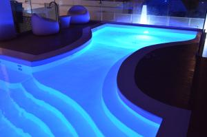 里米尼帕乌拉别墅酒店的一座拥有蓝色灯光的游泳池