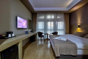 埃斯基谢希尔阿鲁斯酒店的酒店客房带一张床、一张桌子和椅子