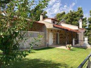 卡桑德里亚Villa Elani的一座带草地庭院的小石头房子
