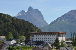 翁达尔斯内斯Grand Hotel - by Classic Norway Hotels的一座白色的大建筑,背景是一座山