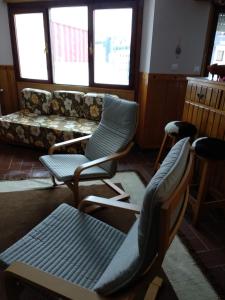 普埃夫拉德利略Peña del viento a pie de pistas estación San Isidro的客厅配有两把椅子和一张沙发