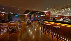 八打灵再也朱兰达马沙拉皇家酒店的一间铺有木地板的酒吧,餐厅内还设有酒吧凳子