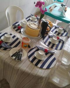 福塔莱萨Pousada Restaurante Sol de Liz的一张桌子,上面有一块蓝白条纹的桌布,上面有一块蛋糕