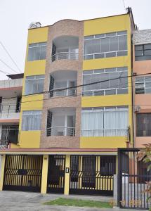 利马Apartamentos Las Americas的黄色的公寓大楼设有阳台