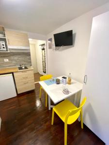 布勒伊-切尔维尼亚Luna's Cozy Apartment, skiin skiout in centre CIR 17的厨房以及带桌子和黄色椅子的用餐室。