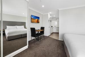 塔姆沃思鸭子宾馆公寓的酒店客房带一张床、一张桌子和椅子
