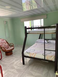 马尼萨莱斯Villa NiNa的一间卧室配有两张双层床和椅子
