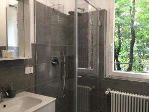 佩罗Domus Pyrus Apartments的带淋浴和盥洗盆的浴室以及窗户。