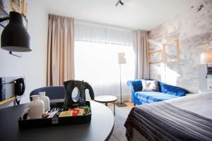 库奥皮奥斯堪库奥皮奥酒店的酒店客房设有一间带一张床和一张桌子的卧室