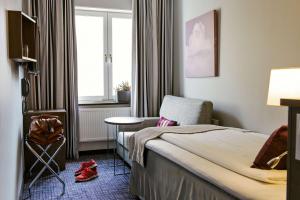 哥德堡斯堪第25号酒店的酒店的客房 - 带一张床、椅子和窗户
