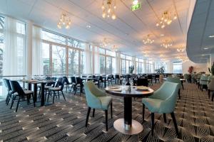 林雪平斯堪迪克林雪平城市酒店的用餐室设有桌椅和窗户。