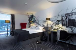 纳姆索斯斯堪迪克岩城酒店的一间卧室配有一张床,墙上挂着一幅画