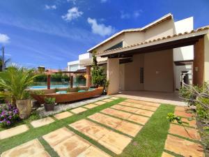 阿拉卡茹Linda casa de praia em Aracaju!的一个带游泳池和房子的后院
