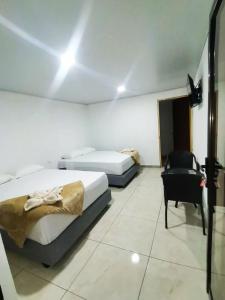 蒙泰韦尔德哥斯达黎加Hostel Cattleya - Monteverde, Costa Rica的酒店客房,配有两张床和椅子