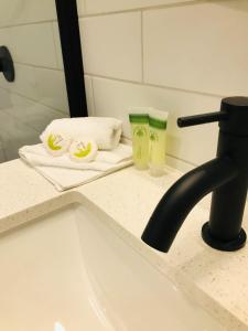阿德莱德The Osmond Motel & Apartments的浴室内带毛巾和水龙头的盥洗盆