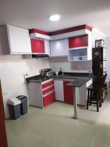 帕斯托Hermoso apartamento en Pasto. Central parque San Andrés的厨房配有红色和白色的橱柜和桌子